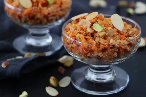 Stock photo showing grated carrot that has been cooked with water, milk and sugar and garnished with almonds. Traditional dessert severed at Indian festivals including Diwali and Holi.