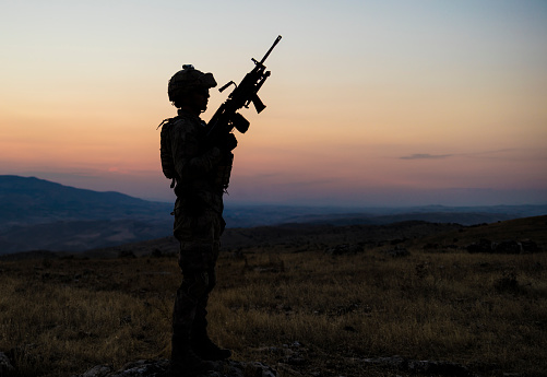 Silhouette of soldier with rifle against a sunset