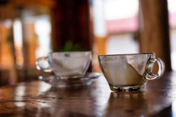 Two used cappuccino cups are on a wooden kitchen counter. Love and togetherness concept without people.