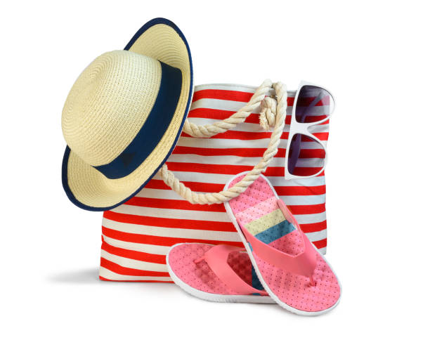 Beach bag with accessories isolated on white Striped red white beach bag with sun hat sunglasses and flip-flops isolated on white sun hat stock pictures, royalty-free photos & images