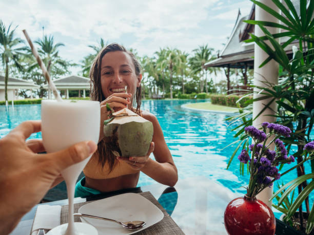 istock Couple cheering with fresh drinks by the poolside 1277975593