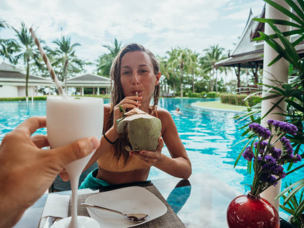istock Couple cheering with fresh drinks by the poolside 1277975599