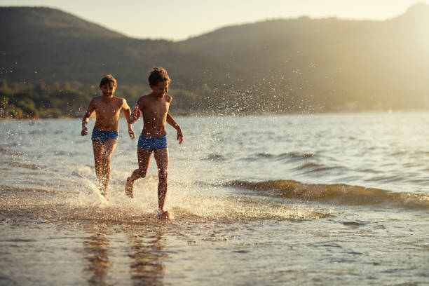 istock Two boys enjoying running by the sea 1277976539