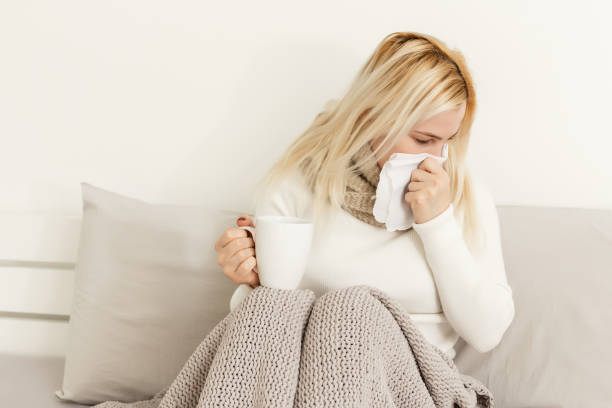 istock Ill woman sitting on her bed while holding her hair 1277976591