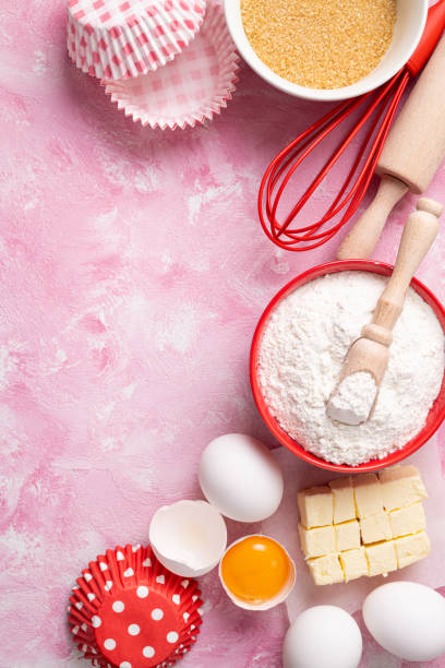istock Baking background. Food ingredients for baking flour, eggs, sugar on pink background flat lay. Baking or cooking cakes or muffins 1277978972
