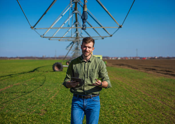 istock Young farmer standing in wheat field and setup irrigation system on tablet. 1277982937