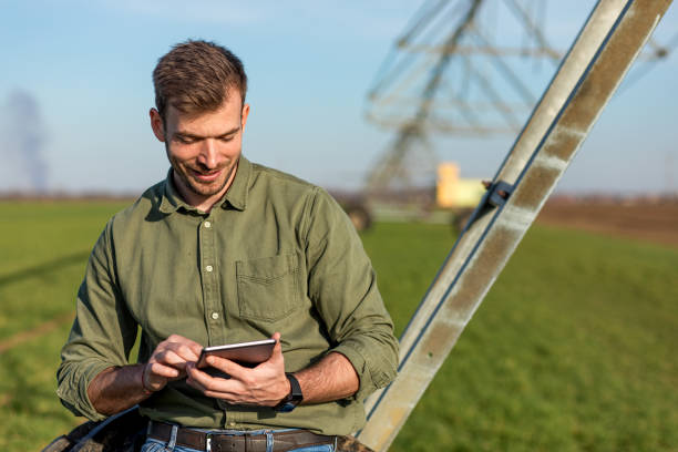 istock Young farmer standing in wheat field and setup irrigation system on tablet. 1277983957