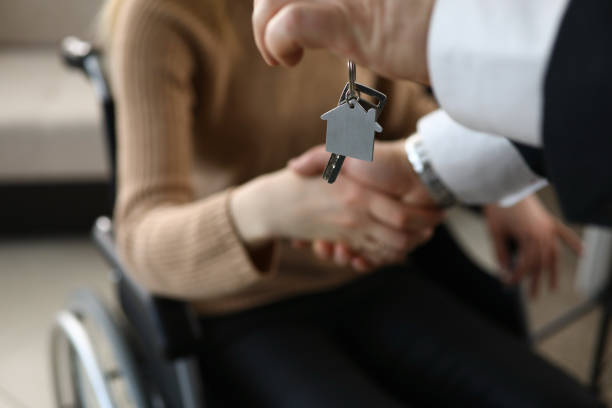istock Man shakes hands with disabled person, house key 1277984267