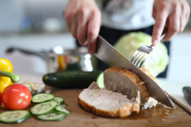 istock Hands chop ready baked pork meat and vegetables 1277984269