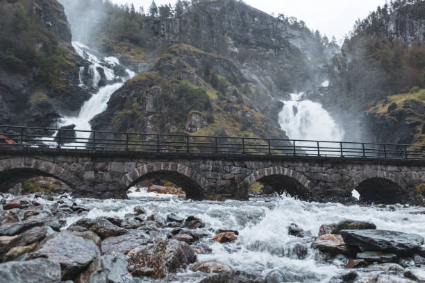 石橋のあるラテフォッセンユニークな滝 - bridge norway odda falling ストックフォトと画像