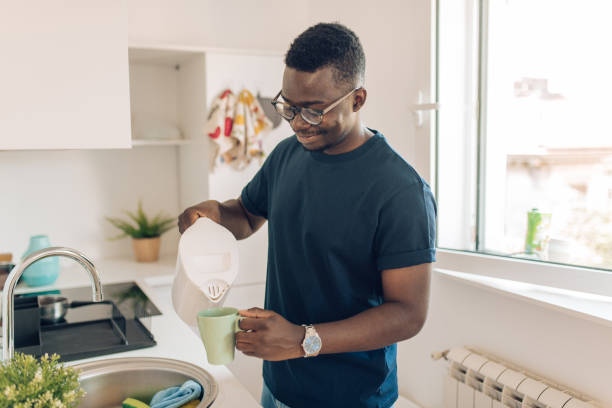 istock Happy young African American  man making his morning coffee 1277984517