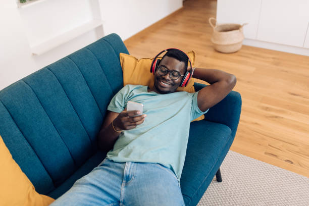 istock Young African-American enjoying on the sofa and having fun online 1277984592