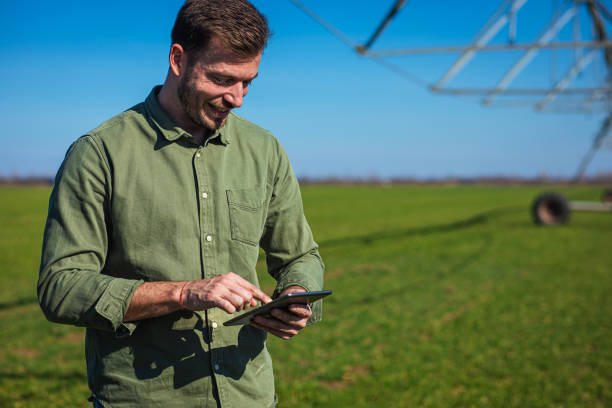 istock Young farmer standing in wheat field and setup irrigation system on tablet. 1277984859