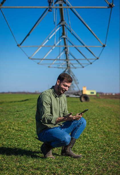 istock Young farmer standing in wheat field and setup irrigation system on tablet. 1277985018