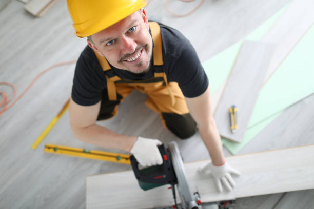 istock Smiling carpenter helmet sawing laminate flooring 1277986430