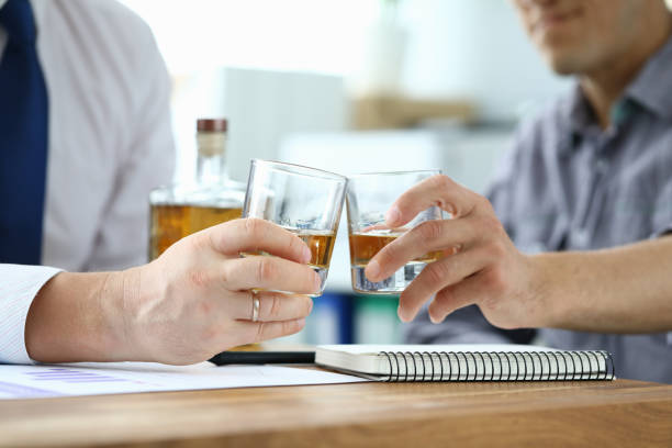 istock Men in suits drink alcohol in workplace at office 1277986435