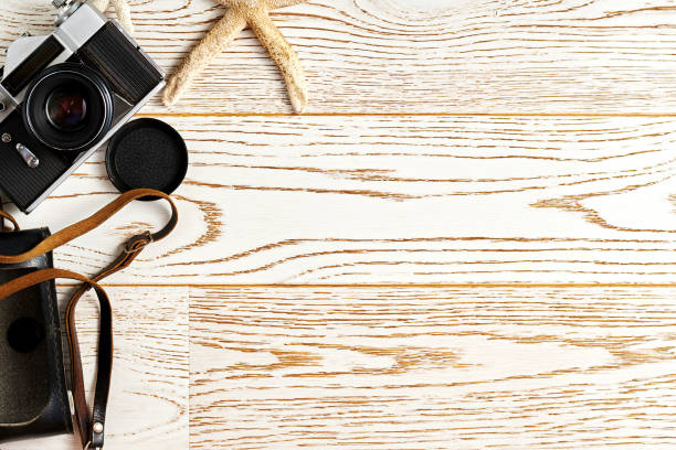 istock Vintage camera and retro travel accessories on the wooden surface. Flat lay template with copy space for text 1277988708