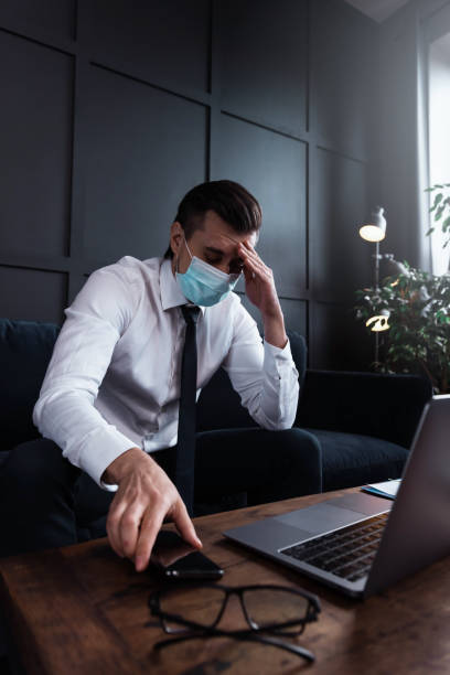 istock Tired businessman with a sickness symptoms wearing prevention mask at work 1277990249