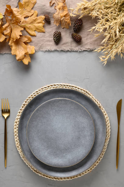 istock Autumn festive table setting with fall golden decor on grey table. View from above. Vertical. 1277993896