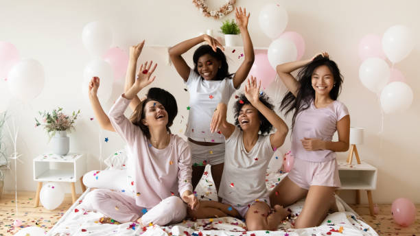istock Energetic young diverse multiethnic girls playing with colorful confetti. 1277996505