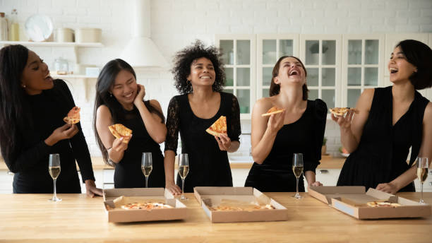 overjoyed young attractive multiracial female besties eating pizza from box. - wedding african descent american culture bride imagens e fotografias de stock