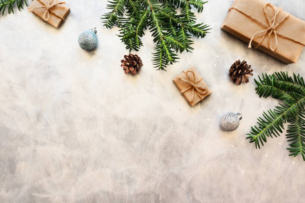 istock Christmas gift boxes wrapped with kraft paper, spruce branches and Christmas balls on gray background. Xmas, Happy New Year and winter holiday concept. Template for greeting card. Flat lay, top view. 1277997068