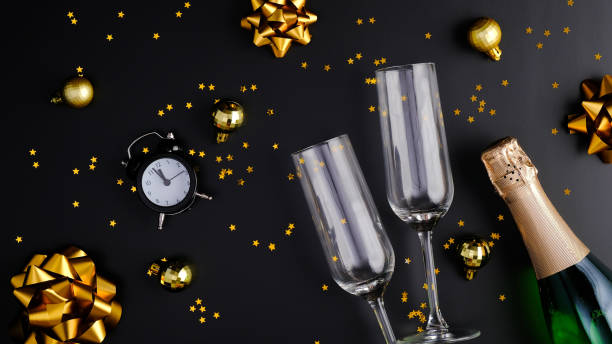 istock New Year Eve party celebration concept. Flat lay composition with two glasses, champagne bottle, glittering confetti and golden decorations. Christmas greeting card. 1277997681