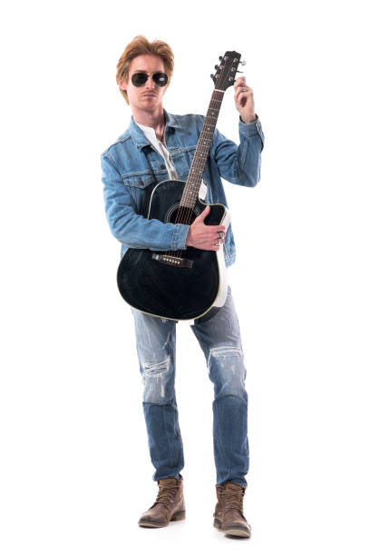 istock Handsome young stylish guitarist getting ready tuning acoustic guitar looking at camera. 1277999558