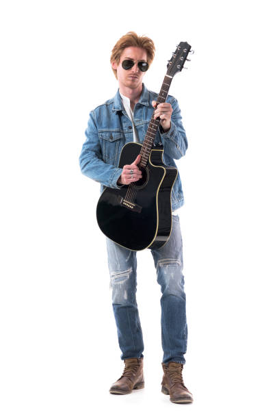 istock Handsome male guitarist playing guitar looking at camera confident. 1278000548