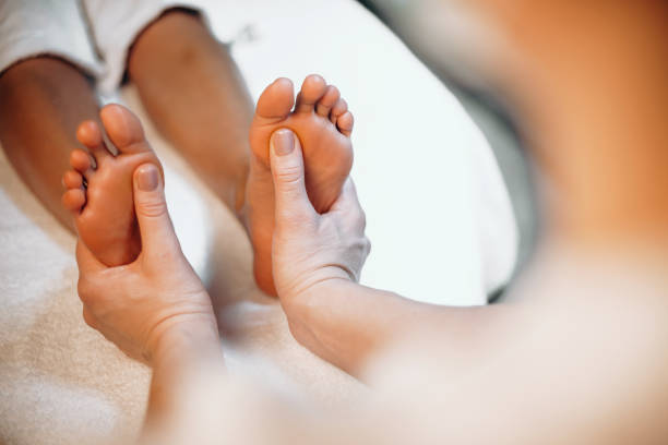 foto ravvicinata di una procedura di massaggio ai piedi eseguita in un centro benessere da un massaggiatore - foot massage foto e immagini stock