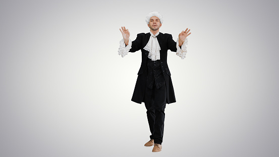 Full length shot. Front view. Man dressed like Mozart expressively finishing conducting while looking at camera on gradient background. Professional shot in 4K resolution. 047. You can use it e.g. in your medical, commercial video, business, presentation, broadcast