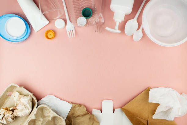 istock Plastic and paper garbage on pink background flat lay top view with copy space. Kitchenware, caps, cup, envelope, egg box, craft paper. Waste recycling, sorting, re-use. Social issues. 1278011499
