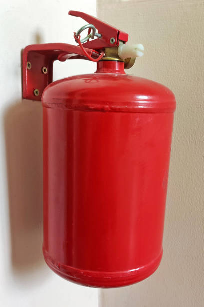istock Red fire extinguisher mounted to a gray wall. Fire extinguishers available in fire emergencies 1278016243