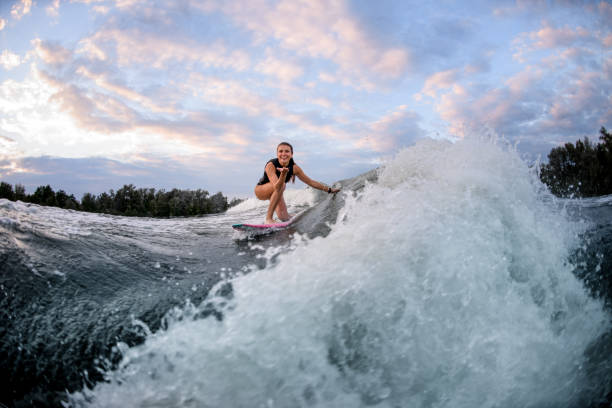 istock Active woman rides wave on surf style wakeboard and touches wave with hand 1278020210