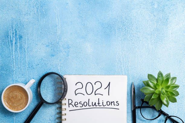 istock New year resolutions 2021 on desk. 2021 goals with notebook, coffee cup and eyeglasses on blue background. Goal, plan, strategy, action, idea concept 1278026345