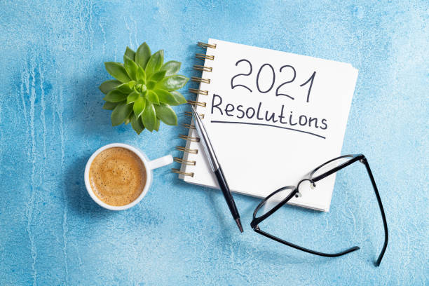 istock New year resolutions 2021 on desk. 2021 goals with notebook, coffee cup and eyeglasses on blue background. Goal, plan, strategy, action, idea concept 1278026826