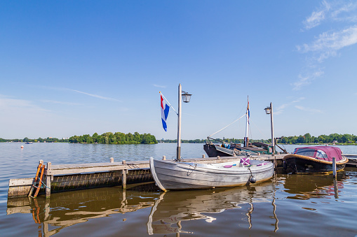 Sloops, sailingboats and motorboats ready for sailing Paterswoldsemeer a lake near Groningen in the Netherlands on a summer day