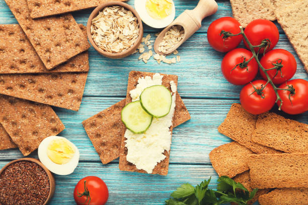 istock Crispbread with cream cheese and vegetables on blue wooden table 1278028086