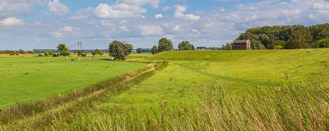 Dutch polder panorama with dyke and bridge near Nijmegen, Gelderland in the Netherlands