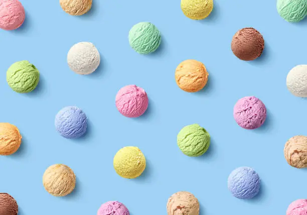 Photo of Colorful pattern of different ice cream scoops on blue background