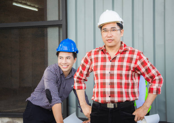 istock Team of Engineer planning group project partners meeting at building site, Man in hard hat standing and looking at camera at construction site 1278030006