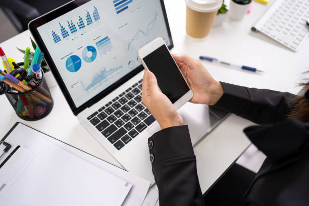 istock Young Asian businessman using a phone with a blank screen on a white desk in the office. 1278033409