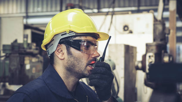 istock Factory worker talking on portable radio while inspecting machinery parts 1278034070
