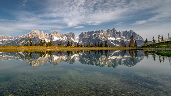 Reflection of Wilder Kaiser mountain range in the waters of astbergsee, Austria.