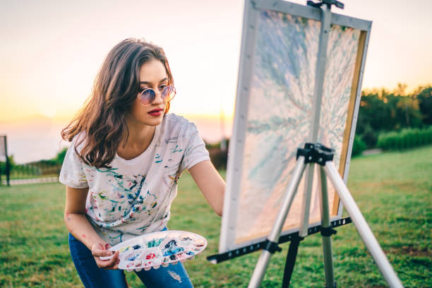 istock Creative young woman painting in nature 1278035523
