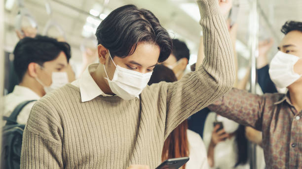istock Traveler wearing face mask while using mobile phone on public train 1278036159