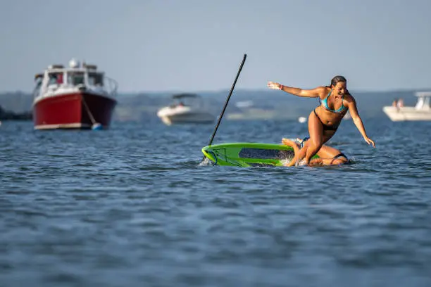 Photo of Girls falling off of their paddle board