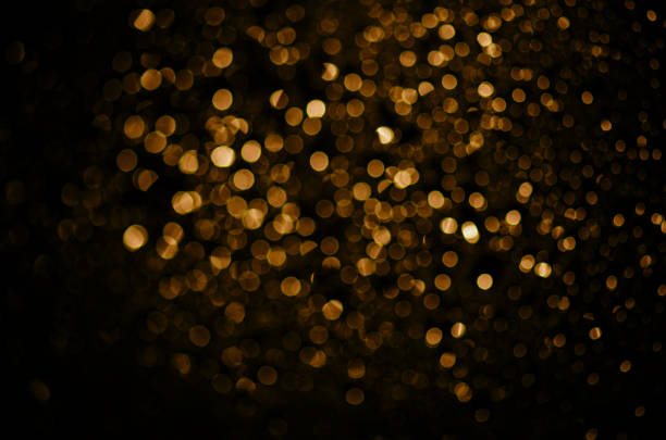 Blur neon gold light circle background. Sparkling firework bokeh dots in retro film filter style. Blur neon gold light circle background. Sparkling firework bokeh dots in retro film filter style. Luxury and classy new year and christmas celebration party textured backdrop. Blurry golden dust particles. new year photos stock pictures, royalty-free photos & images