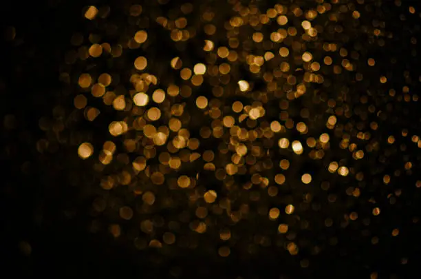 Photo of Blur neon gold light circle background. Sparkling firework bokeh dots in retro film filter style.