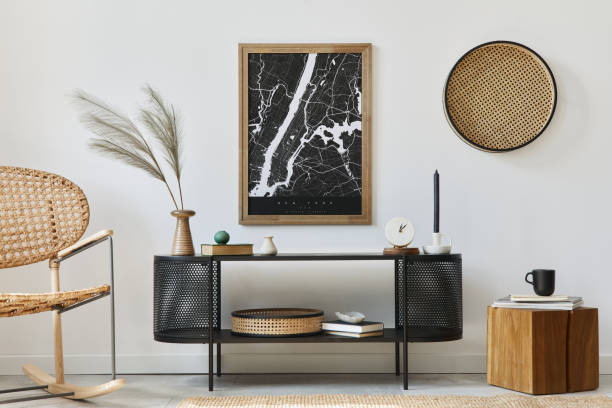 istock Modern scandinavian living room interior with mock up poster frame, design commode, leaf in vase, rattan armchair, book and elegant accessories in stylish home decor. Template. 1278038029